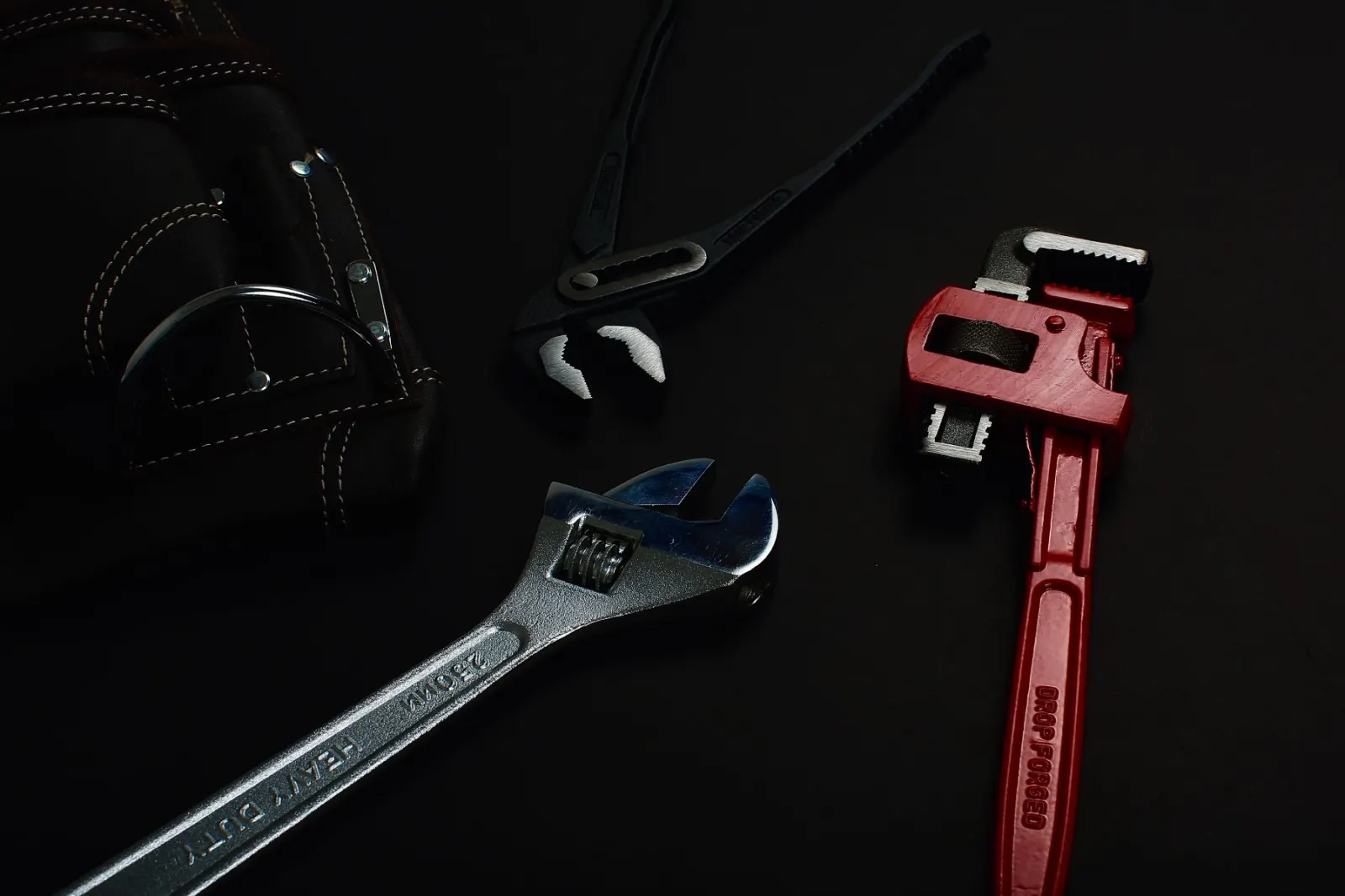 Two pipe wrenches on a workbench
