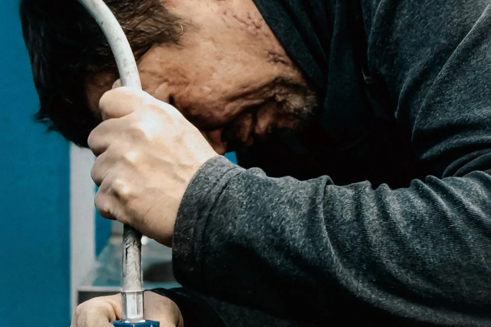 Hands tightening a compression fitting on a pipe with a wrench