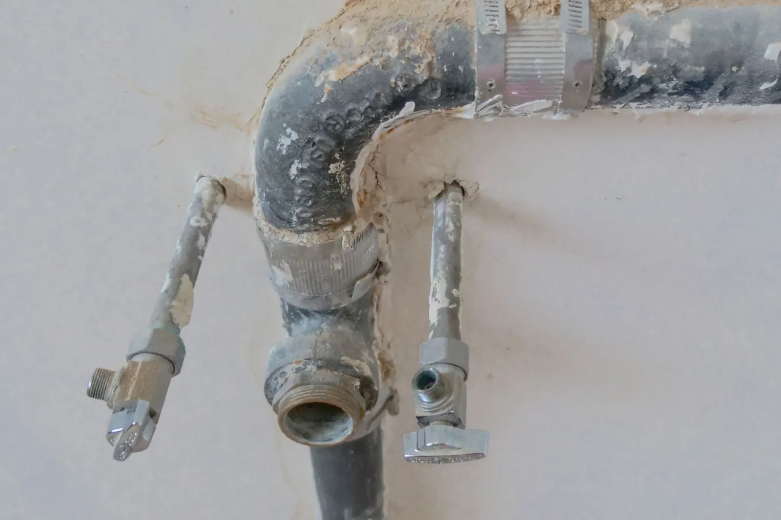 Hands working on the pipework under a kitchen sink