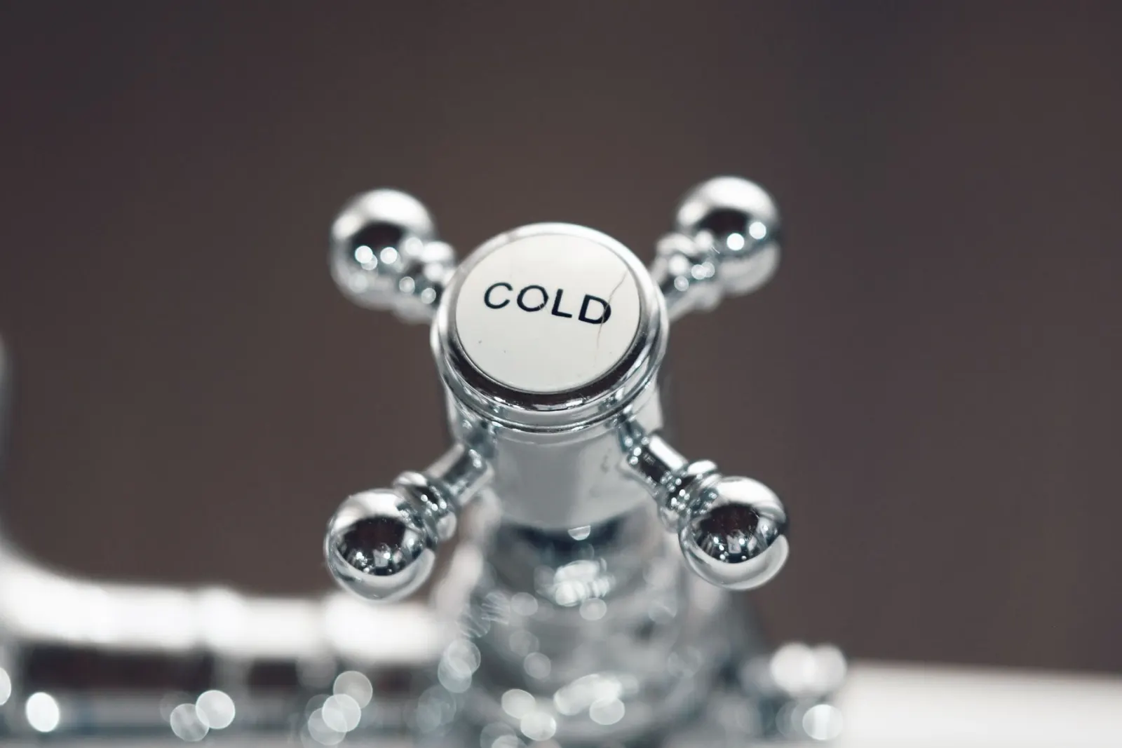 A chrome cross-head tap marked cold